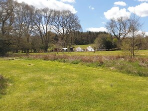 A rural landscape with a grassy field, trees, and several white buildings. - 2 bedroom accommodation in Uckfield (Uckfield)