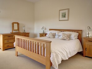 A bedroom with a wooden bed, nightstands, a dresser, and a framed picture on the wall. - Great for large groups looking for a luxury bolthole in the Cotswolds. (Chipping Campden)