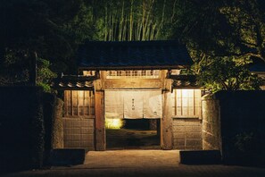 Un torii tradicional japonés de madera con tejado de tejas, que da entrada a un edificio con suelo de madera.