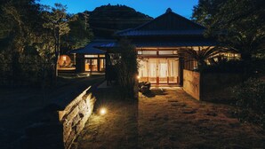 A traditional Japanese building with a wooden structure, a tiled roof, and a stone pathway leading to the entrance. - HOTEL RACCAN (Shibushi)