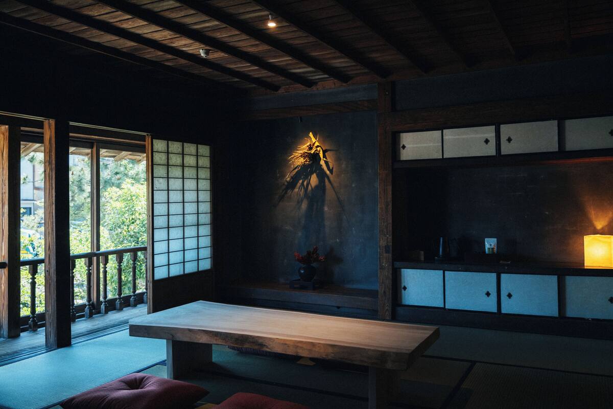Ein traditioneller japanischer Raum mit Tatami-Bodenbelag, einem niedrigen Tisch und Schiebetüren.