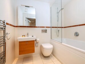 A modern bathroom with a glass shower enclosure, a white sink with a wooden vanity, and a toilet. - 2 bedroom accommodation in Bath (Bath)