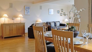 A dining area with wooden furniture, a sofa, and a table set for a meal.