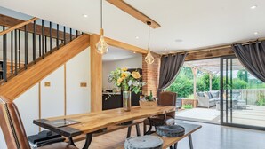 Een modern interieur met een houten eettafel, lederen stoelen en uitzicht op een terras.