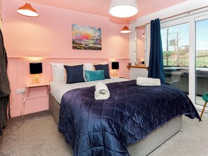 A bedroom with a bed, bedside lamps, a painting, a window with curtains, and a view outside. - Jack's Hideaway - UK5530 (Gatehouse of Fleet)