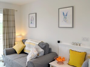 A living room with a grey sofa, a lamp, framed artwork, and a radiator with 'LOVE' spelled out on it. - Beth's Bothy - UK5529 (Gatehouse of Fleet)