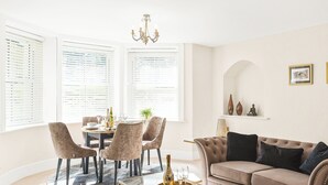 Ein modernes Wohnzimmer mit Esstisch, Stühlen, einer Couch und einem Couchtisch.