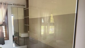 A bedroom with a large sliding door closet, a bed with a white bedspread, and a window with curtains. - Perfect 1-bedroom bed & breakfast with AC in Bengaluru (Bengaluru)