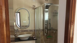 A bathroom with a sink, mirror, and shower. - Perfect 1-bedroom bed & breakfast with AC in Bengaluru (Bengaluru)