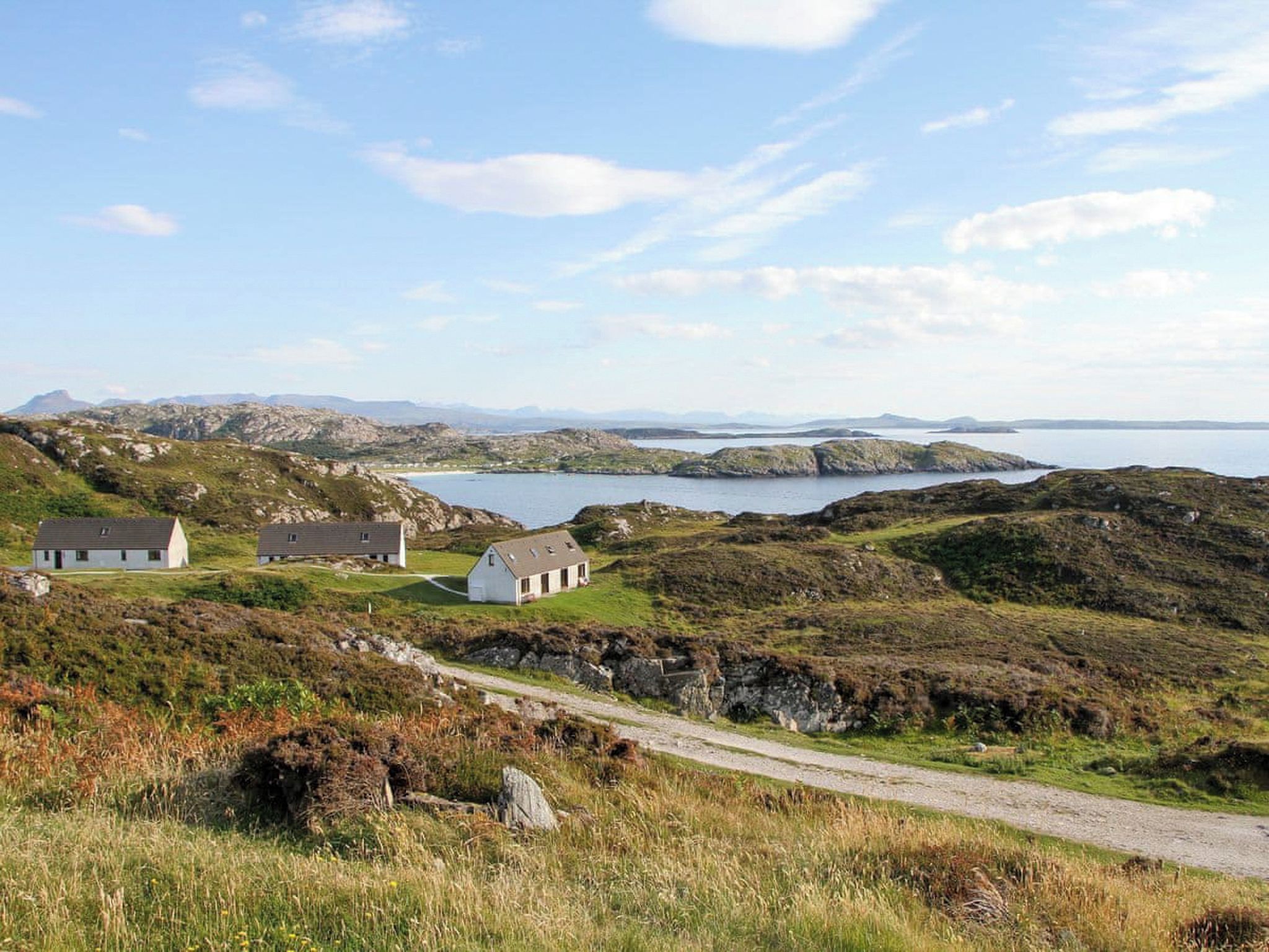 Eine Küstenlandschaft mit weißen Gebäuden, blauem Himmel und Blick auf das Meer.