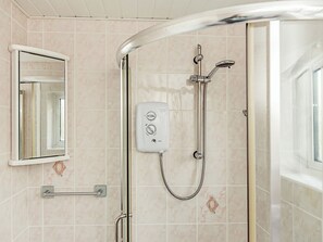 A bathroom with a glass shower enclosure, a handheld showerhead, a handheld shower attachment, and a towel rack. - 3 bedroom accommodation in Flookburgh (Flookburgh)
