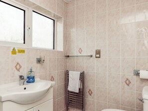 Une salle de bain équipée d’un lavabo, de toilettes et d’un porte-serviettes.