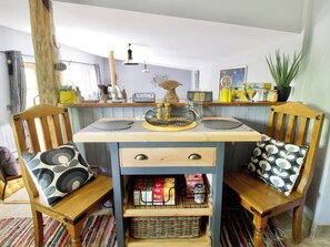 Une cuisine avec des chaises en bois, un îlot central et divers ustensiles de cuisine.