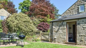 Um edifício de pedra com um pequeno alpendre e uma porta de entrada.