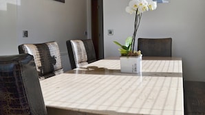 A conference room with a table, chairs, and a potted orchid. - 3 bedroom accommodation in Brynteg, near Benllech (Brynteg, near Benllech)