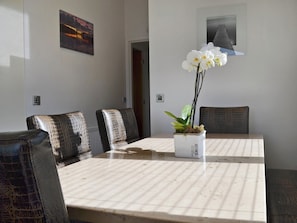 A conference room with a table, chairs, and a potted orchid. - 3 bedroom accommodation in Brynteg, near Benllech (Brynteg, near Benllech)