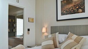 A neatly made bed with striped pillows, a bedside lamp, and a framed picture on the wall. - 3 bedroom accommodation in Brynteg, near Benllech (Brynteg, near Benllech)
