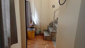 A narrow hallway with wooden flooring leading to a staircase. - Shri Kishori Kunj Home Stay (Vrindavan)