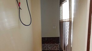 A narrow hallway with wooden flooring, a tiled section near the end, and a window with curtains. - Shri Kishori Kunj Home Stay (Vrindavan)