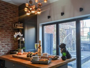 Un café acogedor con pared de ladrillo, mostrador de madera y un amplio ventanal con vista a la calle.