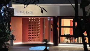 La entrada de un hotel de diseño moderno, con una fachada geométrica y un pequeño jardín delantero.
