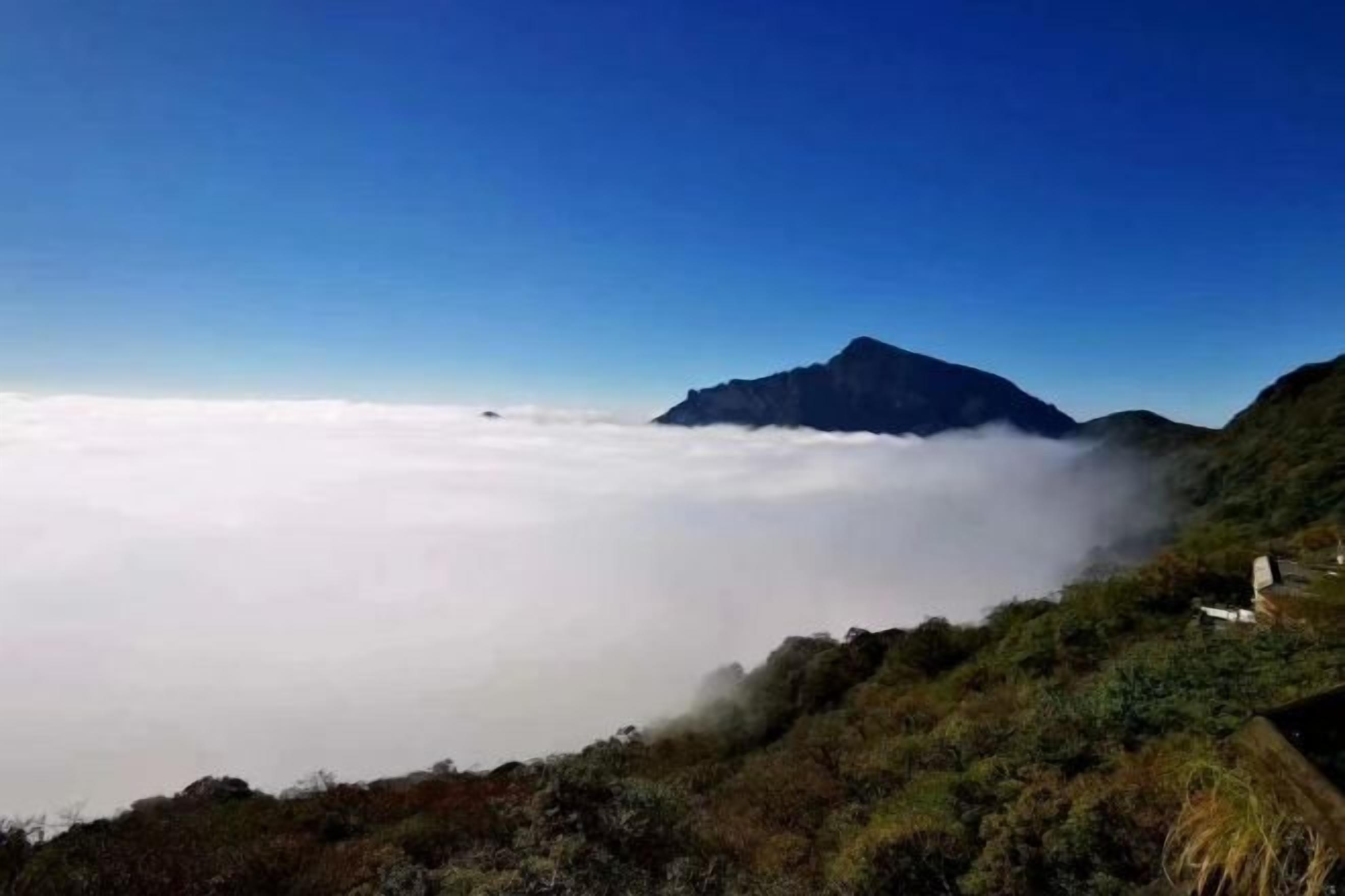 Paisaje montañoso con cielo despejado y vista de las nubes abajo.