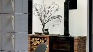 Un interior moderno con una chimenea, una pila de armarios grises y una planta decorativa.