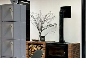 A modern interior with a fireplace, a stack of grey cabinets, and a decorative plant.