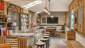 A bar area with wooden walls, a pool table, and stools. There are bottles and a menu on the wall. - 5 bedroom accommodation in Rudyard Lake (Rudyard Lake)