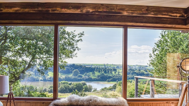 A room with large windows, a wooden bench, and a painting easel. - This bespoke designer property has the wow factor in abundance. (Rudyard Lake)