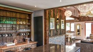 A kitchen with a granite countertop, wooden cabinetry, and a variety of glassware and utensils. - This bespoke designer property has the wow factor in abundance. (Rudyard Lake)