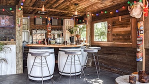 A rustic bar area with wooden beams, a bar counter, stools, and a decorative bull head. - This bespoke designer property has the wow factor in abundance. (Rudyard Lake)