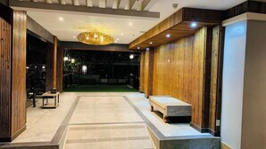 Un intérieur moderne avec un mur en bois, un banc et une table avec une lampe.