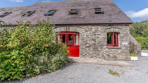 A stone building with a red door and windows, labeled "The Coach House." - The Coach House - UK35246 (Llanfyrnach)