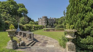 A stone pathway leading to a castle-like building surrounded by lush greenery. - 1 bedroom accommodation in Kirkmichael, near Ayr (Kirkmichael, near Ayr)