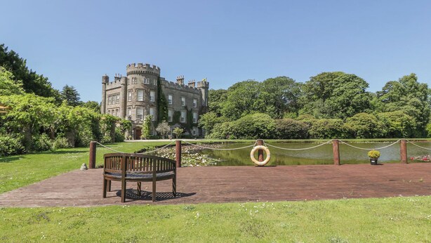 A castle-like building with a moat and a wooden bench in the foreground. - 1 bedroom accommodation in Kirkmichael, near Ayr (Kirkmichael, near Ayr)