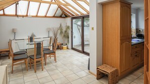 A spacious patio with a dining area, wooden cabinets, and a view through the glass doors. - Sea Breeze at Fishermans Dock (Poole)