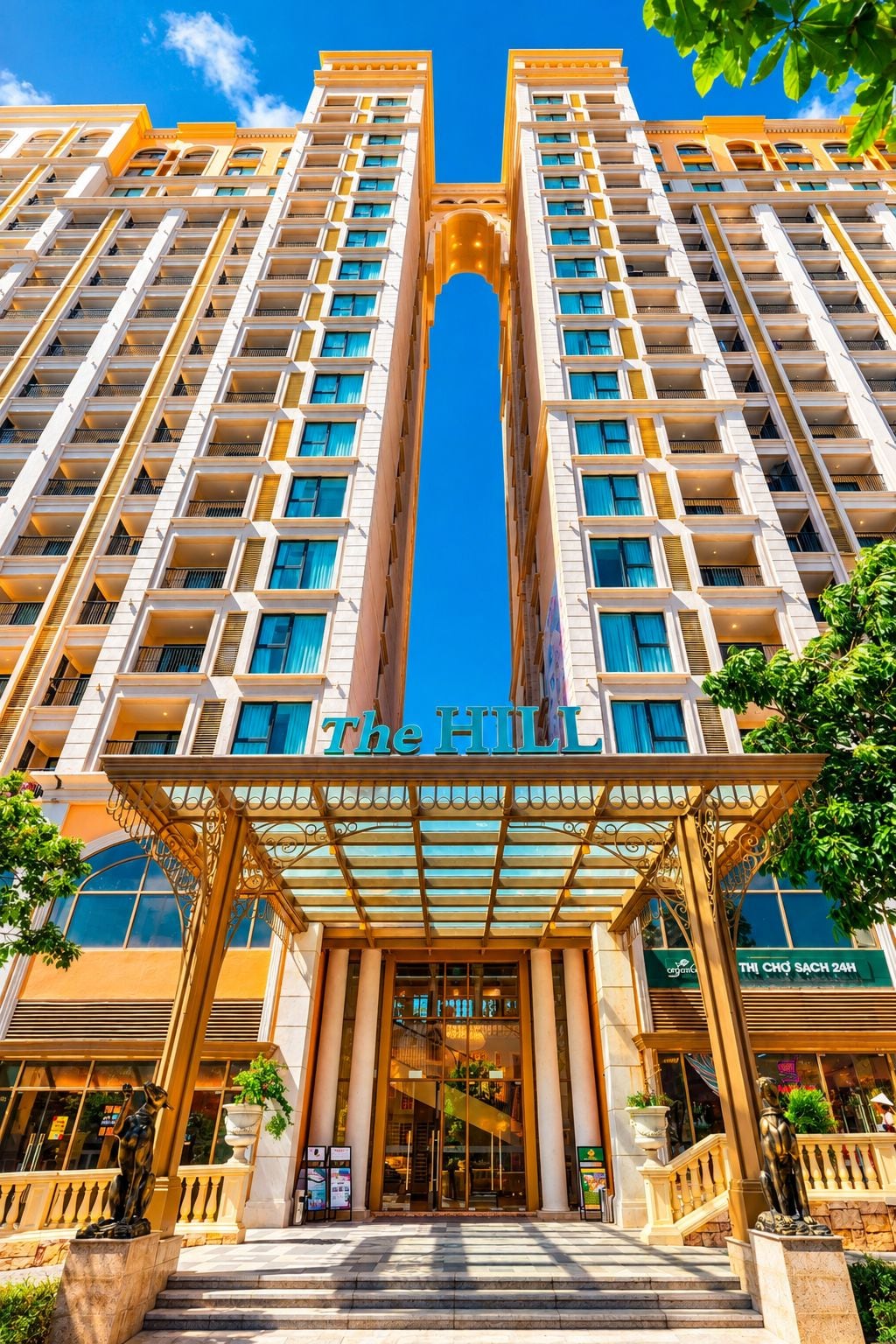 Un hotel moderno de gran altura, con entrada central, varios balcones y cielo despejado.