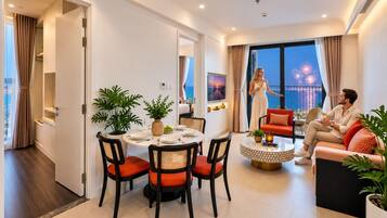 Una sala moderna con comedor, un conjunto de sofás y vista a fuegos artificiales.