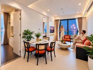Una sala moderna con comedor, un conjunto de sofás y vista a fuegos artificiales.
