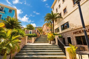 A staircase leading to a building with a stone facade and a sign that reads 'NICE'. - Crystal Apartment Hillside Phu Quoc (Phu Quoc)