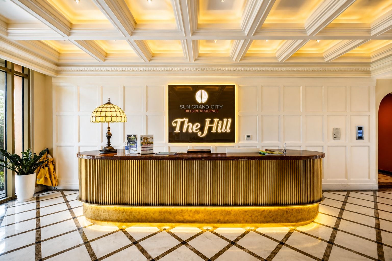 A reception desk with a sign reading 'Sun Grand City Hillside Residence The Hill'.