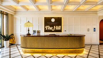 Un comptoir d’accueil avec une pancarte indiquant : « Sun Grand City Hillside Residence, The Hill ».