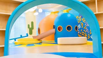 A children's play area with a blue archway, a cactus decoration, and a slide.