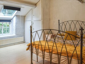 A bedroom with a bed, a window, and a radiator. - 3 bedroom accommodation in Tremadog (Tremadog)