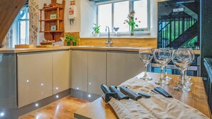 A modern kitchen with a wooden countertop, a sink, and a window with a view of a staircase. - 3 bedroom accommodation in Crackington Haven (Crackington Haven)