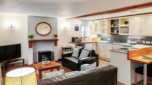Una sala de estar moderna con chimenea, un sofá, un televisor y un comedor.