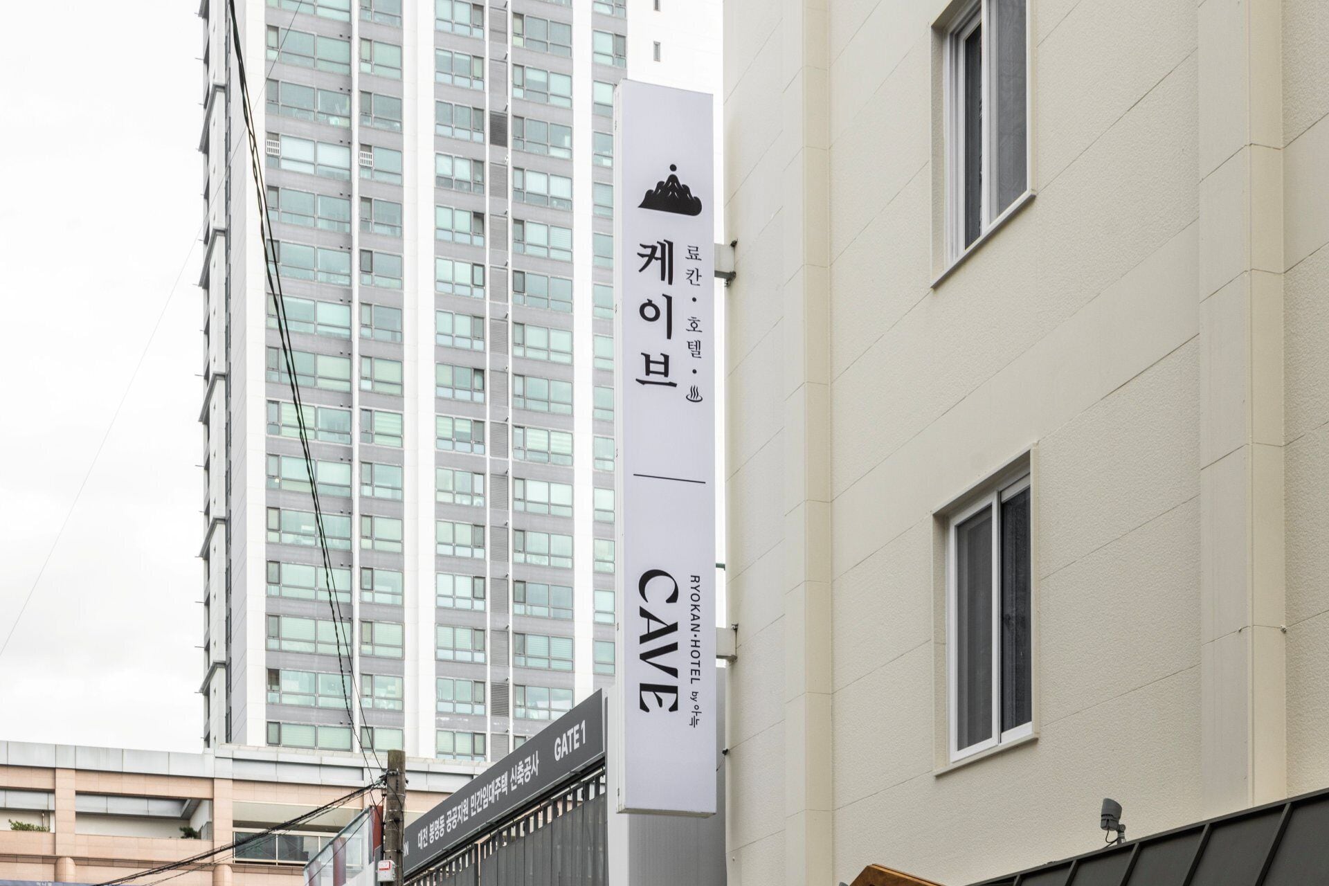 A building with a sign for 'RYOKAN-HOTEL by RYOKAN' and a 'GATE1' sign below it.