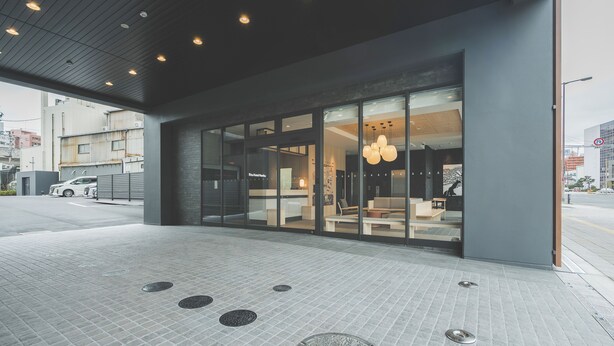 A modern building with large glass windows, a tiled floor, and a visible entrance. - Rita Hotel Namba (Osaka)