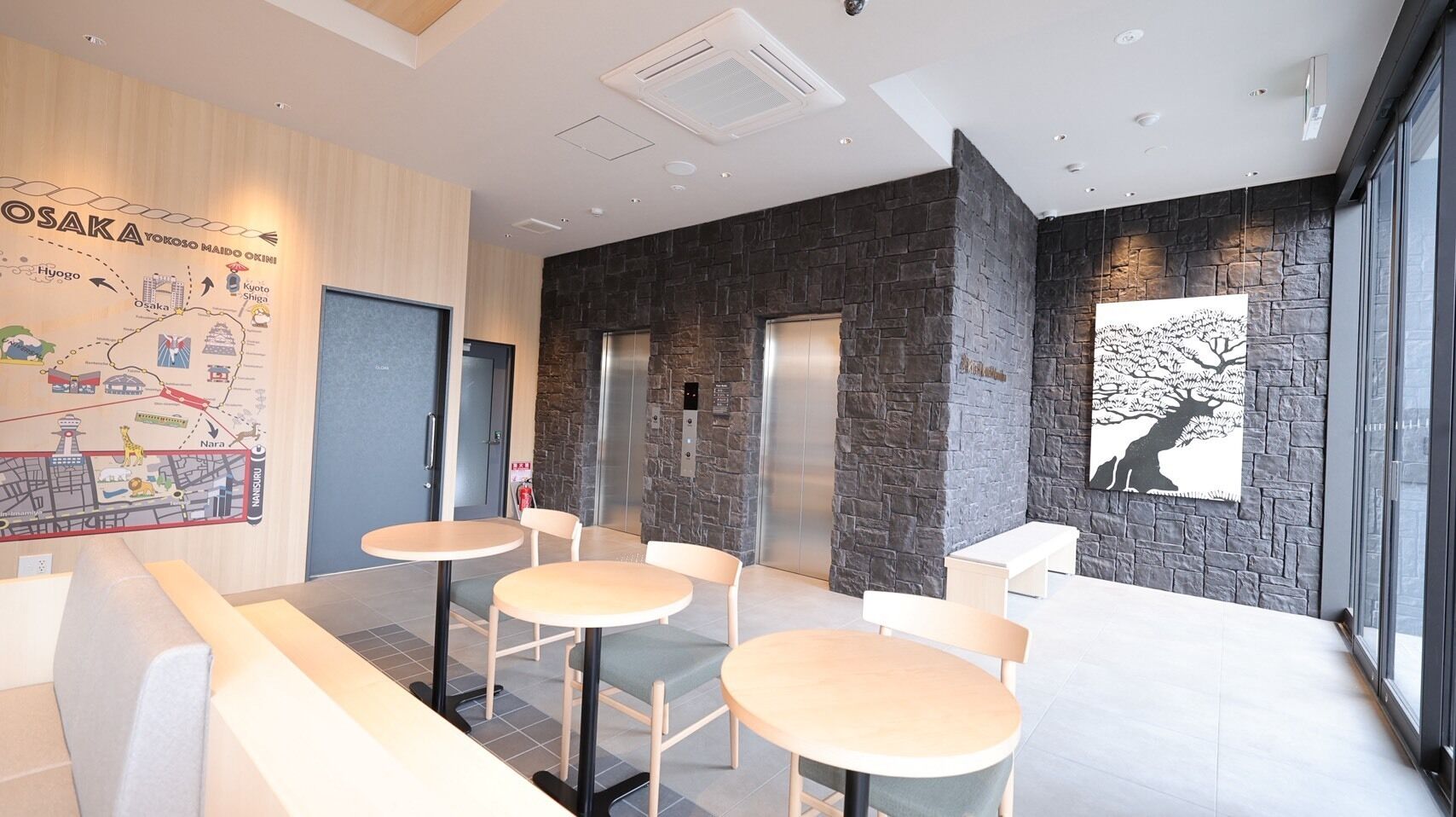 A modern interior with a stone accent wall, a map mural, and a large window with a tree silhouette.